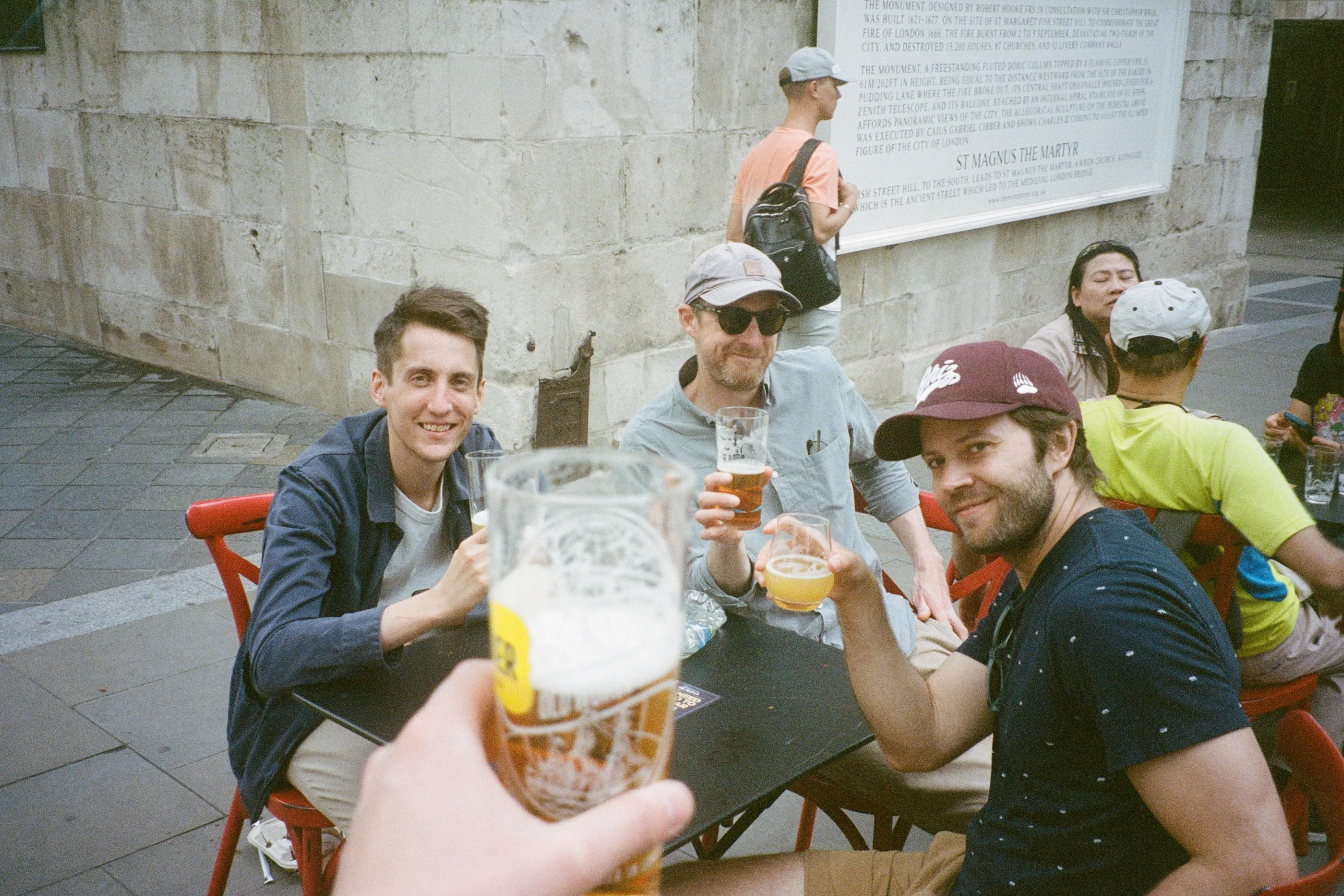Three men raise beer glasses in a toast