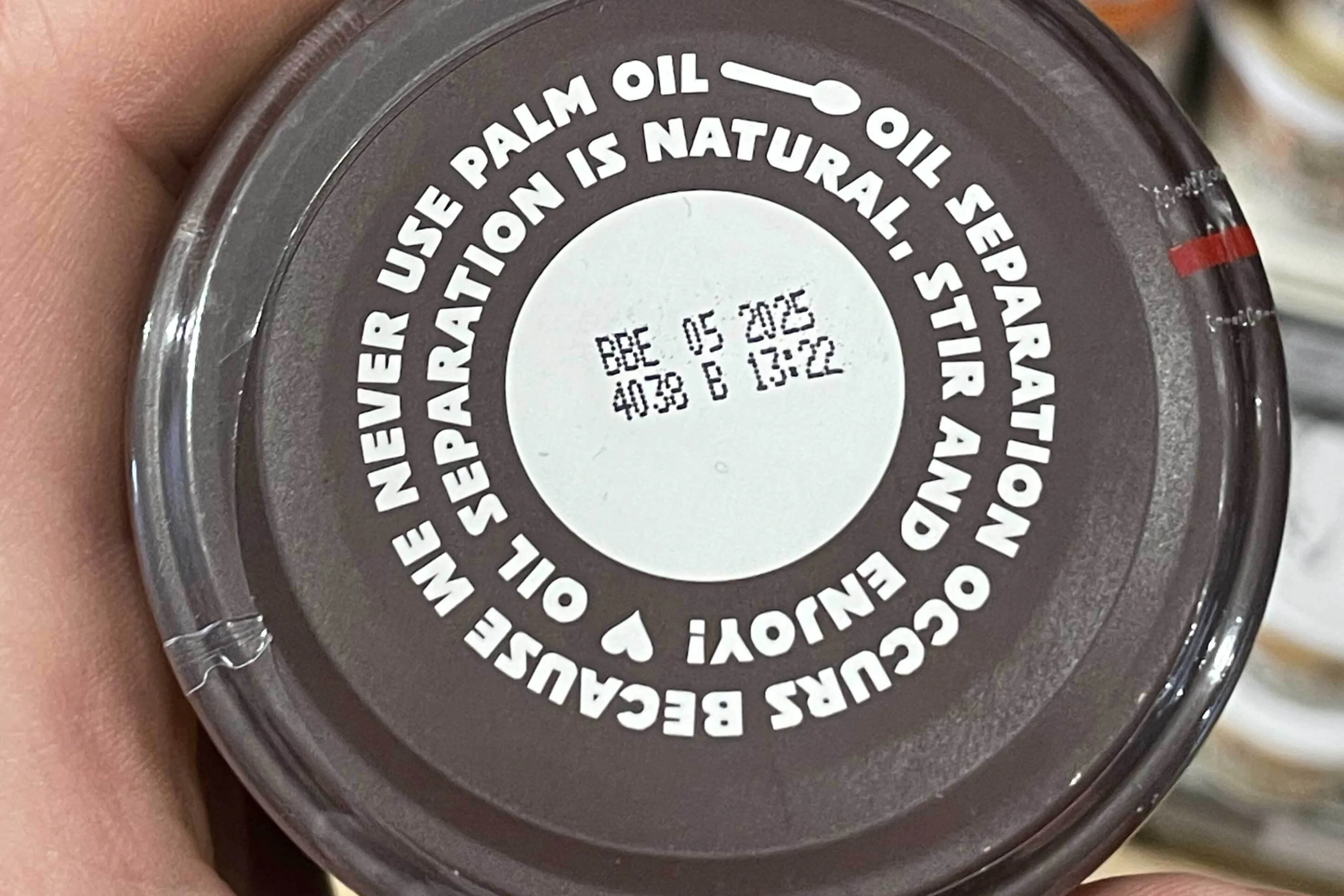 A brown lid from of a jar of peanut butter, with printed instructions to stir and enjoy.