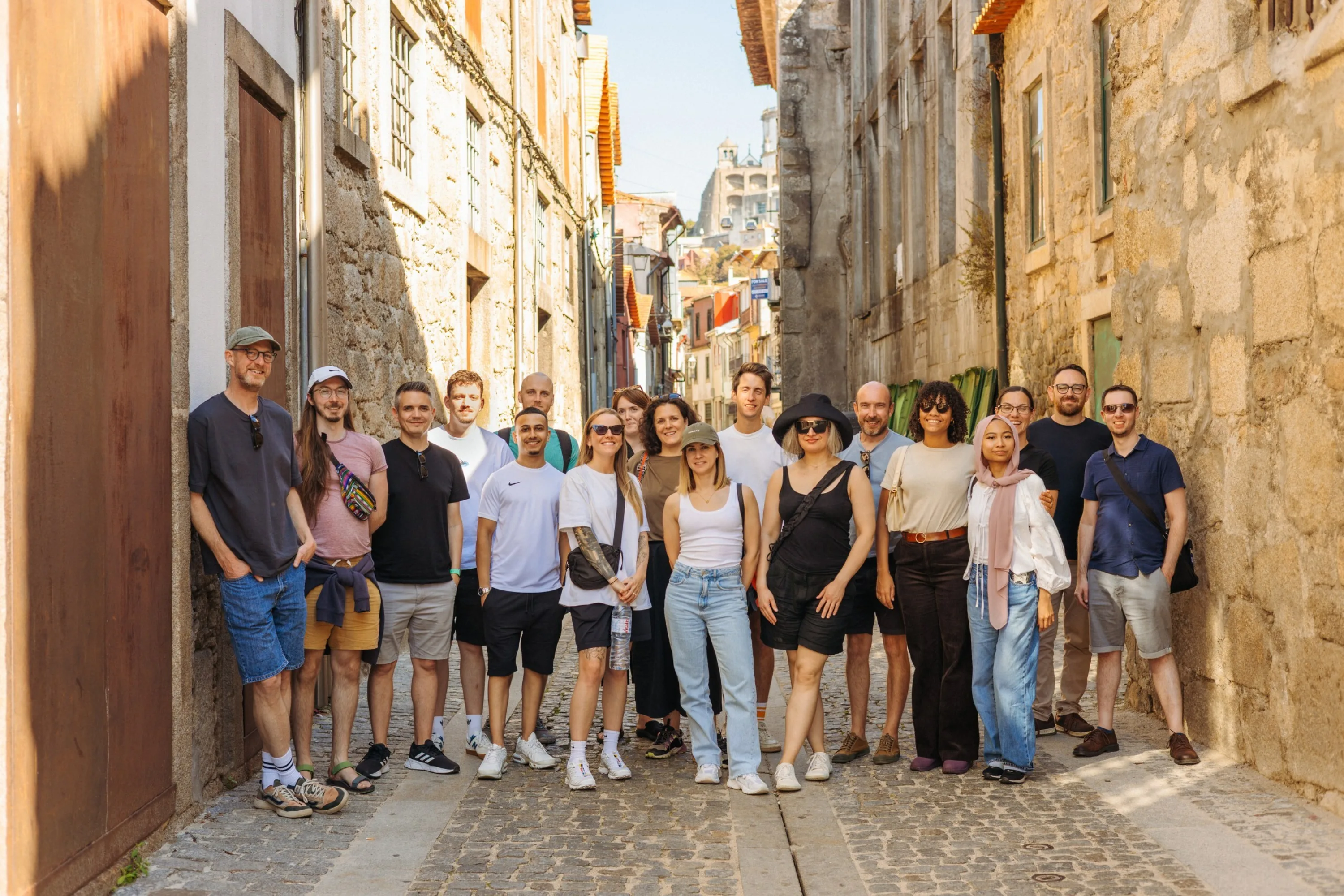 About 20 people stand in a small euroean street for a team photo