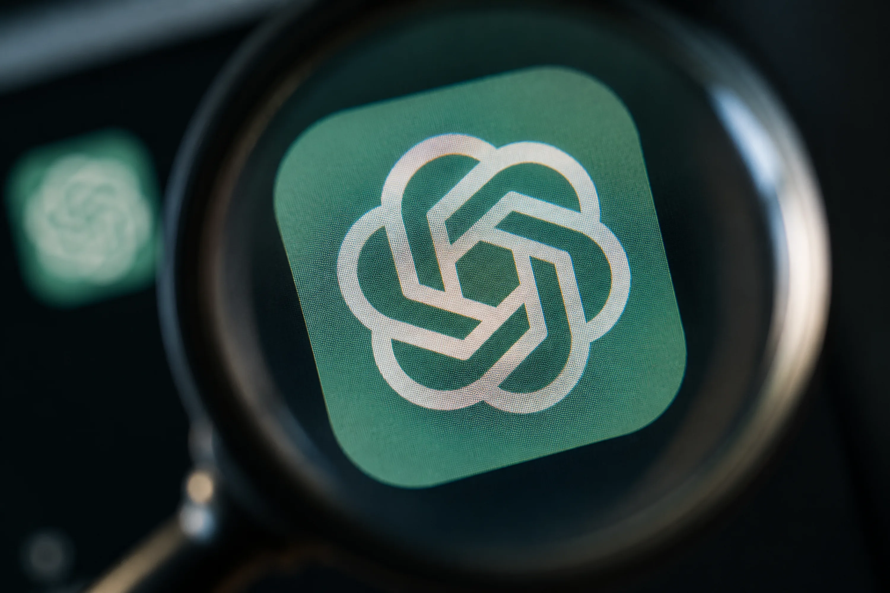 ChatGPT logo viewed through a magnifying glass.