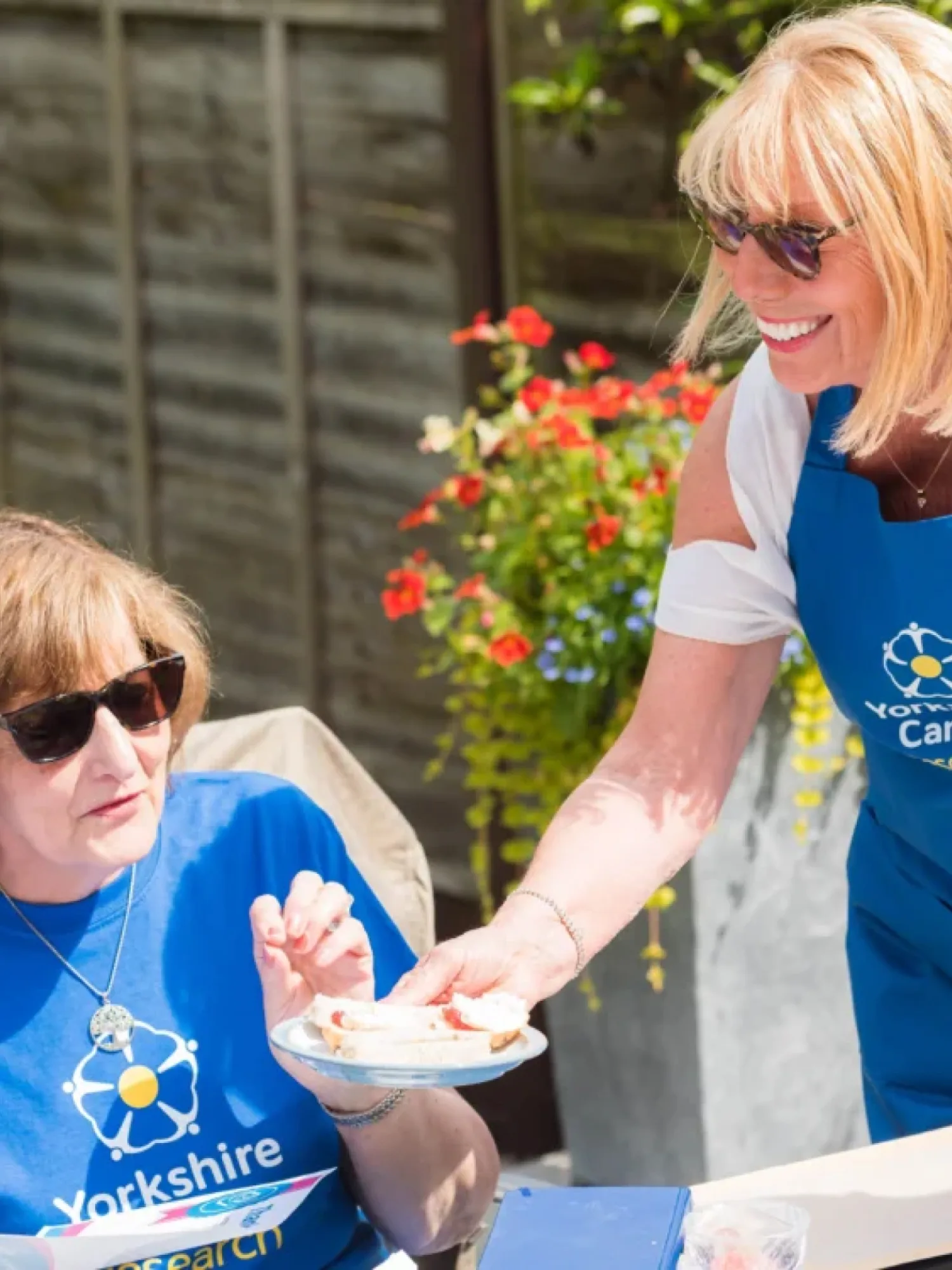 Two women in Yorkshire cancer research t-shirts at a coffe and cake fundraiser