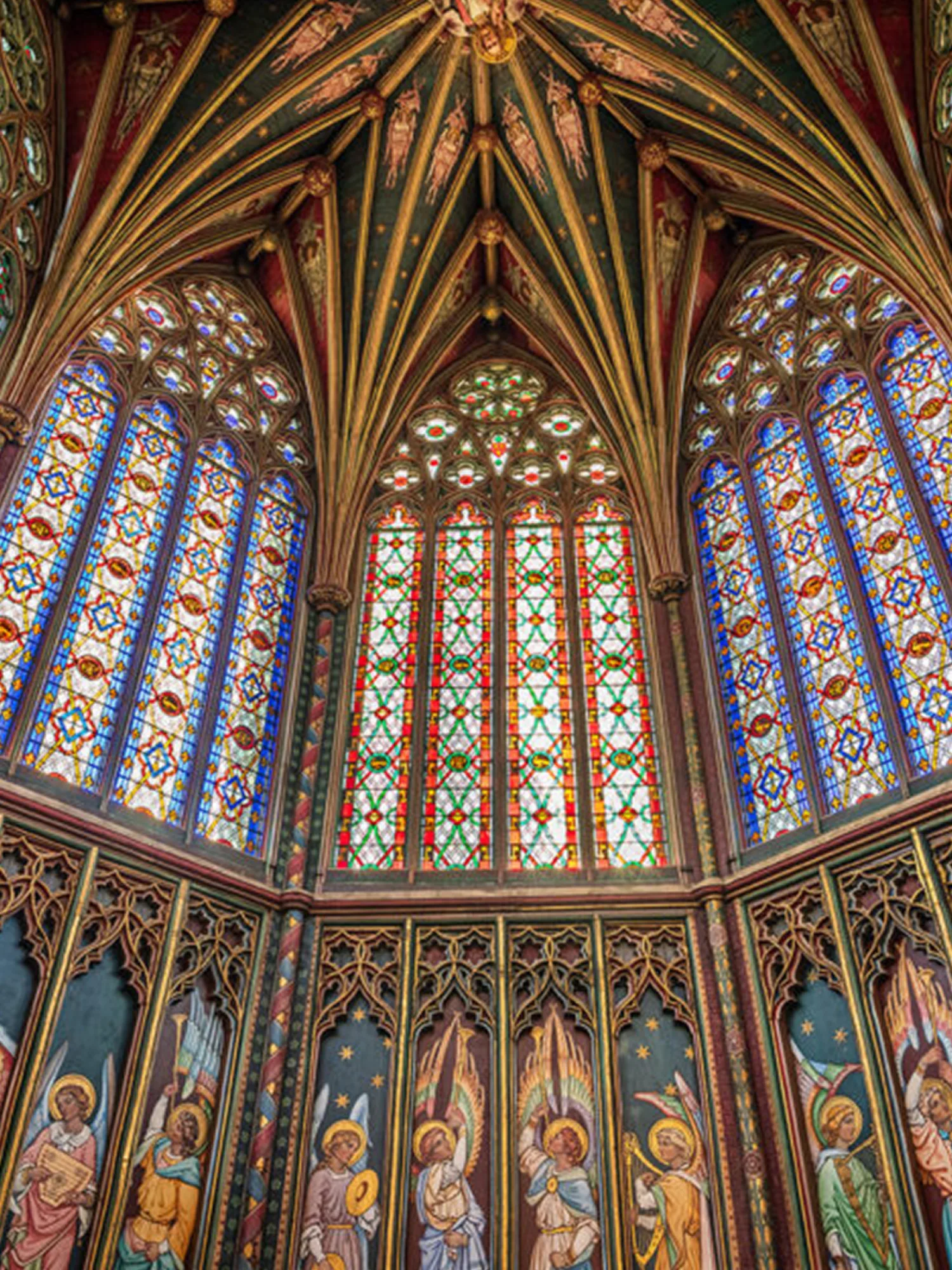 Looking up at ornate stained glass windows and colourfully painted wooden paneling