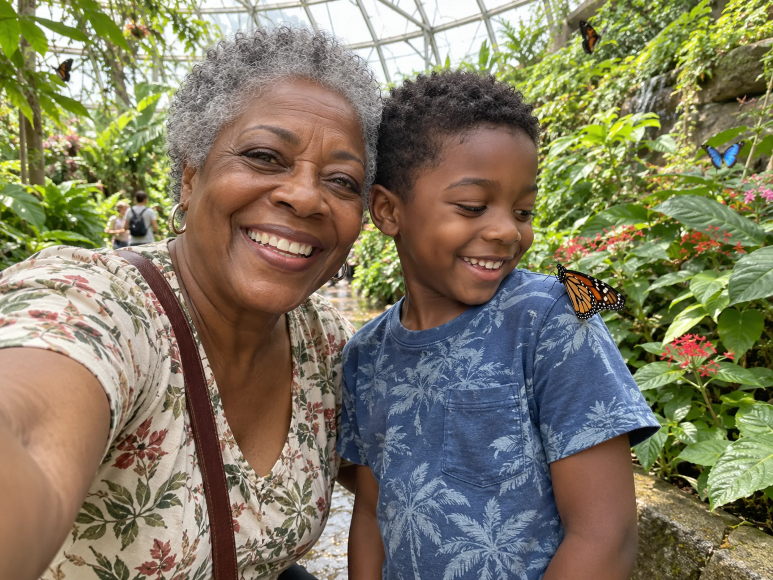 W grandmother and grandson take a selfie in a butterfly house