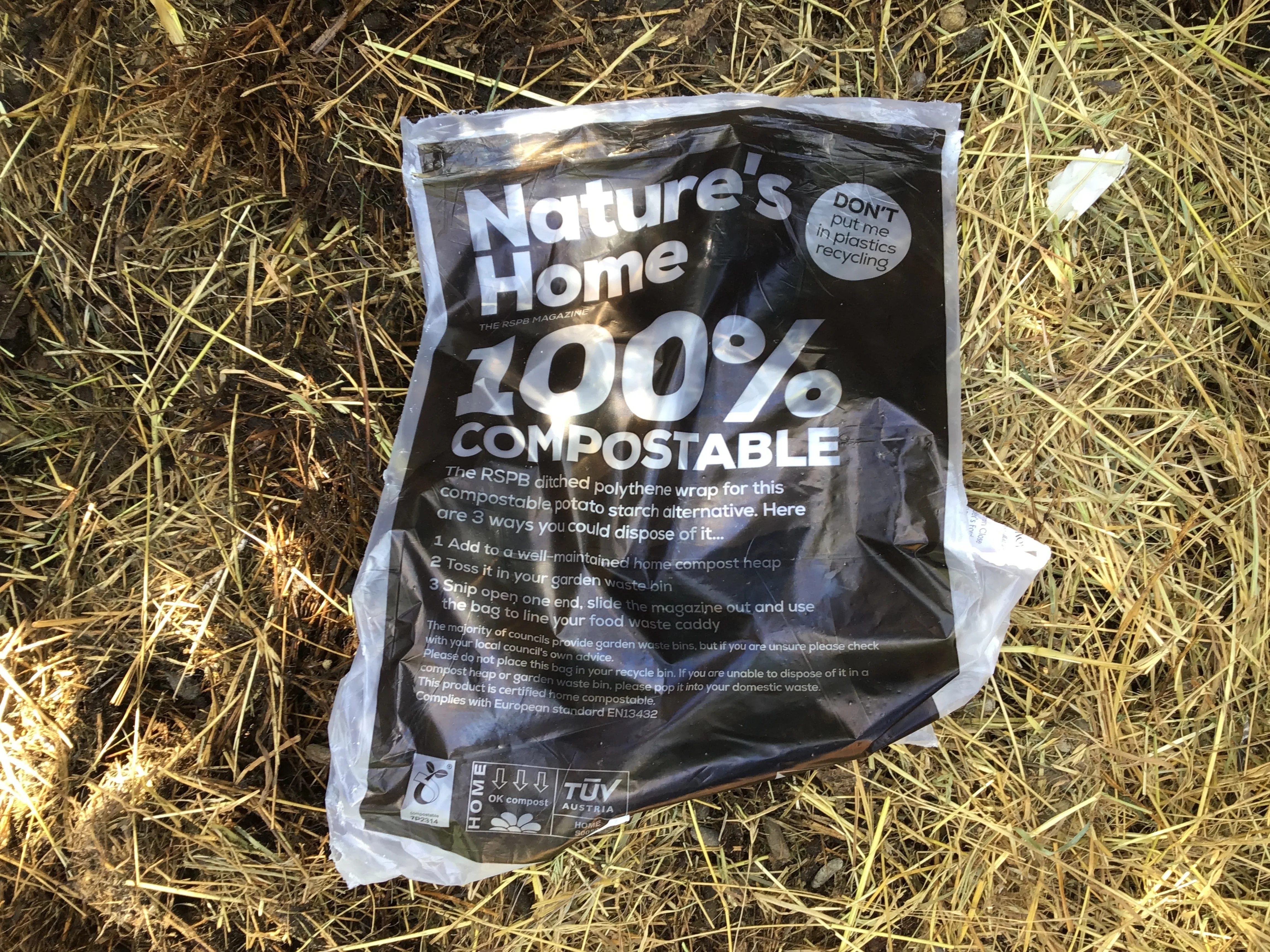 A compostable potato starch bag on a background of straw